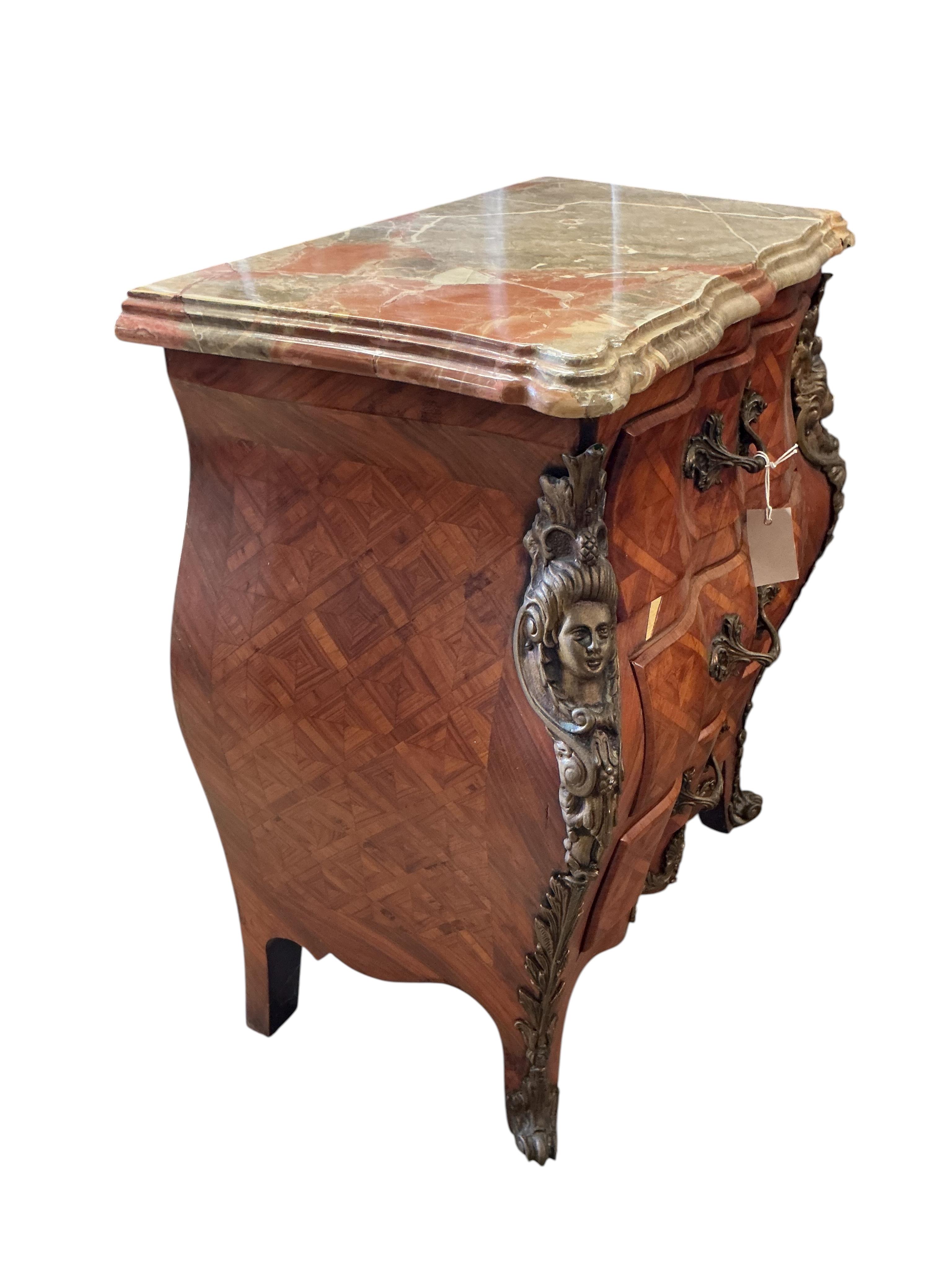 A pair of French transitional style bombe gilt metal mounted onyx top three drawer bedside chests, width 61cm, depth 33cm, height 71cm